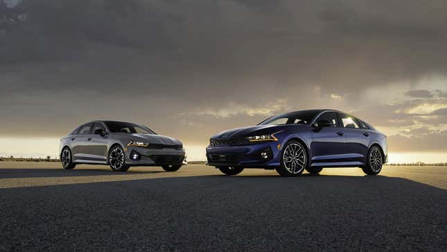 A photo of two Kia K5 sedans at sunset. 