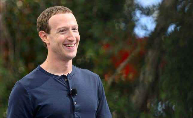 Close-up photo of Mark Zuckerberg who is smiling in a navy henley