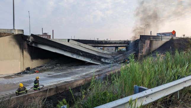 The collapsed portion of I-95 with two firefighters in the foreground.