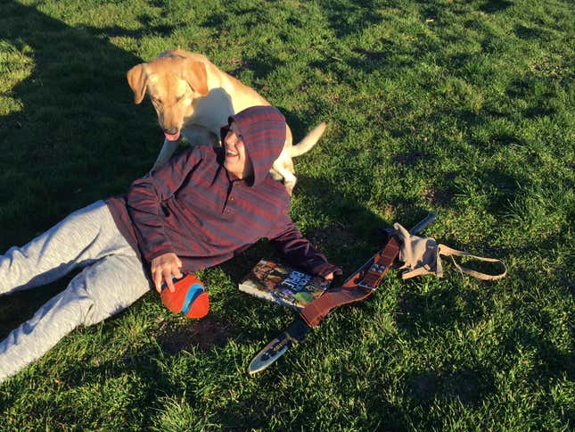 This 2016 image provided by Mark Mansfield shows his son Canyon Mansfield and dog Kasey playing in the grass in Pocatello, Idaho. The boy was seriously injured in 2017 and his dog was killed when a cyanide device that is used to kill coyotes and other predators emitted a cloud of poison while they were hiking near their home. The Bureau of Land Management made public its decision to end the use of the devices on public lands Wednesday, Nov. 22, 2023. (Mark Mansfield via AP)