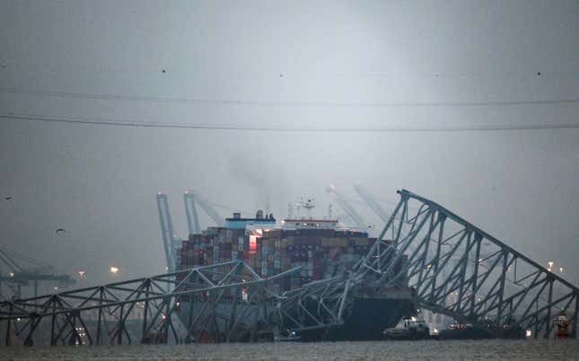 The collapsed Francis Scott Key Bridge lies on top of the container ship Dali in Baltimore, Maryland, on March 27, 2024. Authorities in Baltimore were set to focus on expanding recovery efforts on March 27 after the cargo ship slammed into the bridge, causing it to collapse and leaving six people presumed dead. All six were members of a construction crew repairing potholes on the bridge when the structure fell into the Patapsco River at around 1:30 am (0530 GMT) on March 26. 