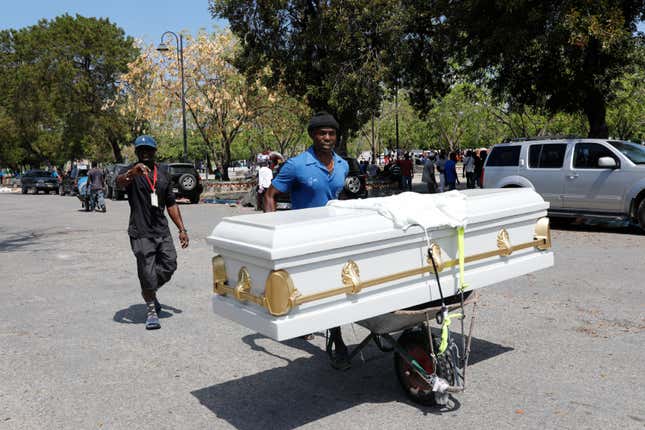 A man transports a coffin using a wheelbarrow, in Port-au-Prince, Haiti, Friday, March 8, 2024. (AP Photo/Odelyn Joseph)