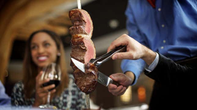 Meat being sliced for diner at Fogo de Chao