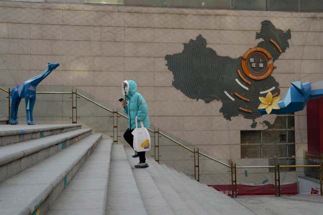 A resident walks through a partially shuttered Evergrande commercial complex in Beijing, Monday, Jan. 29, 2024. Chinese property developer China Evergrande Group on Monday was ordered to liquidate by a Hong Kong court, after the firm was unable to reach a restructuring deal with creditors. (AP Photo/Ng Han Guan)