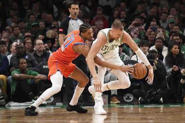 3. April 2024;  Boston, Massachusetts, USA;  Oklahoma City Thunder Guard Aaron Wiggins (21) stößt den Ball vom Boston Celtics Center Kristaps Porzingis (8) in der ersten Halbzeit im TD Garden.