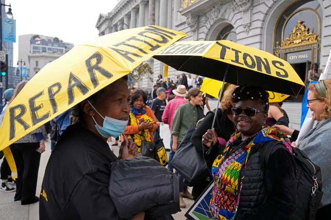 Carrie Carter, right, waits for the start of a rally in support of reparations for African Americans outside City Hall in San Francisco, Tuesday, Sept. 19, 2023. City supervisors will hear from the public Tuesday on draft reparations proposals, including a $5 million lump-sum payment to every eligible Black adult and guaranteed annual incomes of at least $97,000. 