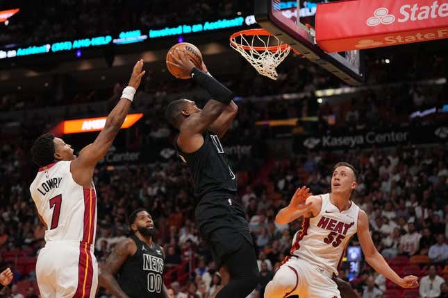 Nov 1, 2023; Miami, Florida, USA; Brooklyn Nets guard Lonnie Walker IV (8) puts up a shot between Miami Heat guard Kyle Lowry (7) and forward Duncan Robinson (55) during the first half at Kaseya Center.