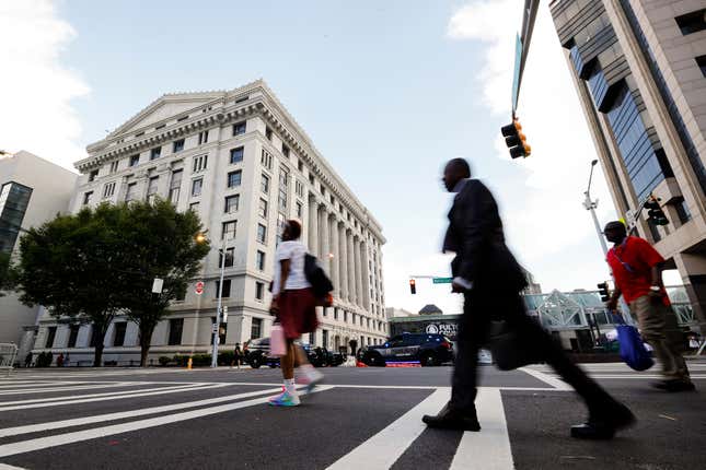 FILE - People cross the street near the Fulton County Courthouse, Aug. 14, 2023, in Atlanta. Court and other systems in Fulton County, Georgia’s largest county is still repairing damage inflicted on its government offices by a cyberattack a month ago. Hackers in late January 2024 shut down online systems and phone service in Fulton County, which includes most of Atlanta.(AP Photo/Alex Slitz, File)