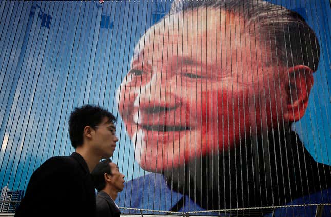 Men walk past a billboard featuring the late Chinese leader Deng Xiaoping, also known as the father of modern China, Thursday, Oct. 21, 2010 in Shanghai, China. China's rapid growth slowed in the latest quarter as Beijing steered its expansion to a more sustainable level, possibly cutting its contribution to a global recovery. (AP Photo/Eugene Hoshiko)