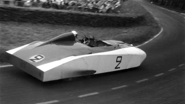 A black and white photo of a vintage Cadillac race car at Le Mans. 