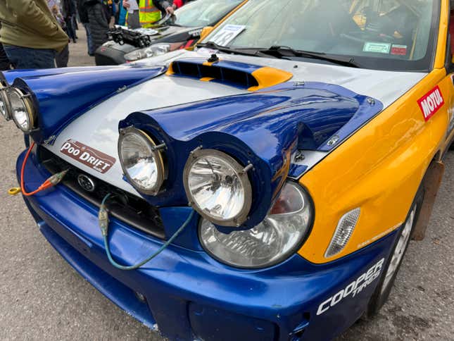 Parte delantera de un coche de rally Subaru WRX azul, blanco y amarillo