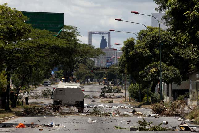 A Bolivarian National Guard vehicle drives down a barren street during a clash between opposition protesters and the Bolivarian National Guard