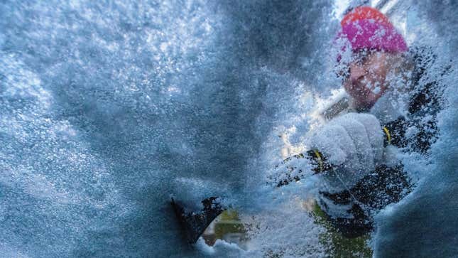  A woman clears snow and ice from a car in the early morning. It is set to remain wintry in the coming days.