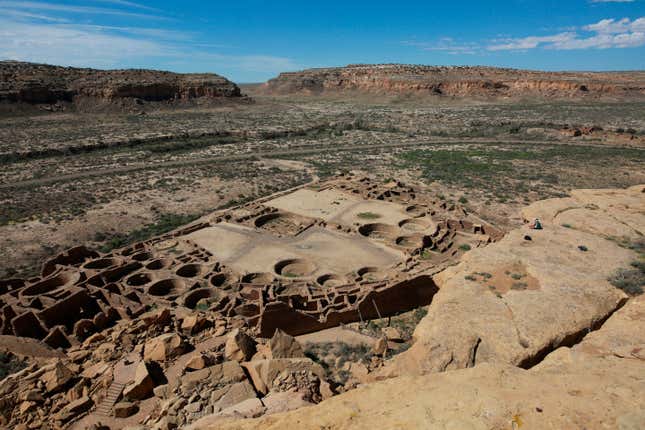 FILE - A hiker sits on a ledge above Pueblo Bonito, the largest archeological site at the Chaco Culture National Historical Park, in northwestern New Mexico, Aug. 28, 2021. New oil and natural gas leasing will be prohibited on state land surrounding Chaco Culture National Historical Park, an area sacred to Native Americans, for the next 20 years under an executive order by New Mexico Land Commissioner Stephanie Garcia Richard on Wednesday, Dec. 13, 2023. (AP Photo/Cedar Attanasio, File)