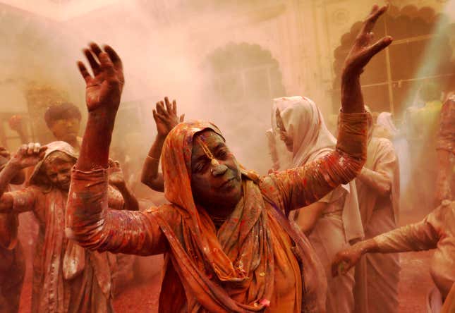 A widow daubed in colours dances during Holi celebrations at a temple at Vrindavan in Uttar Pradesh, India.