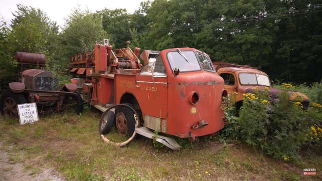 A photo of a rusting fire truck parked outside. 