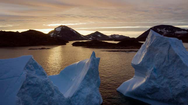 Icebergs floating as the sun rises near Kulusuk, Greenland.