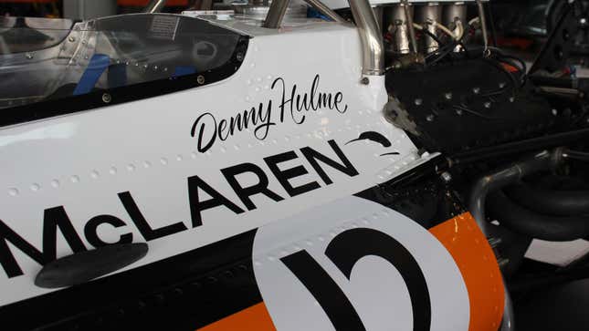 A photo of a McLaren IndyCar with orange, black and white stripes. 