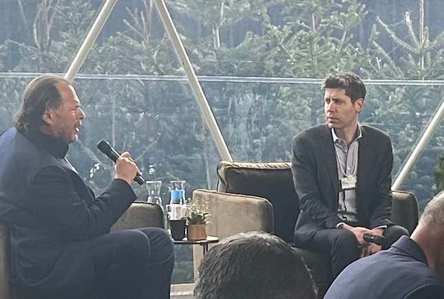 Marc Benioff asks Sam Altman a question on a stage where the two are seated in chairs