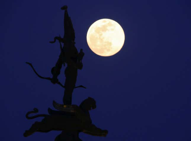The moon rises behind the Independence Monument in Almaty, Kazakhstan on March 20.