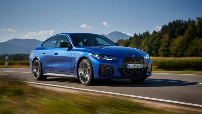 A photo of a blue BMW i4 Sedan driving on a highway. 