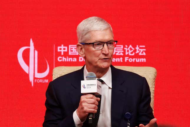 Tim Cook speaking, holding a microphone, in front of a red backdrop that says China Development Forum