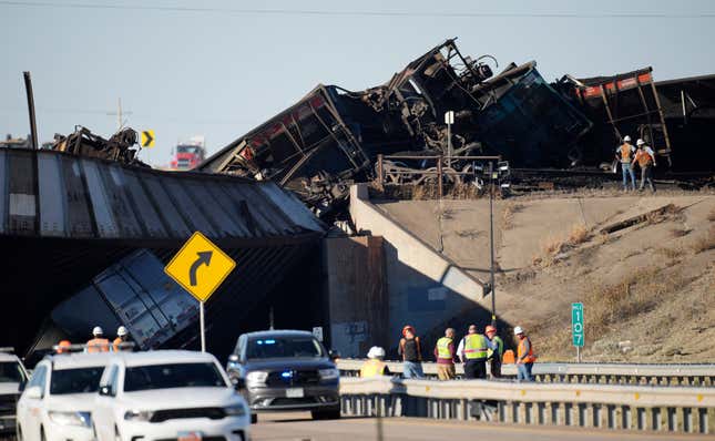 Workers toil to clear cars that derailed in an accident over Interstate 25 northbound, Monday, Oct. 16, 2023, north of Pueblo, Colo. (AP Photo/David Zalubowski)