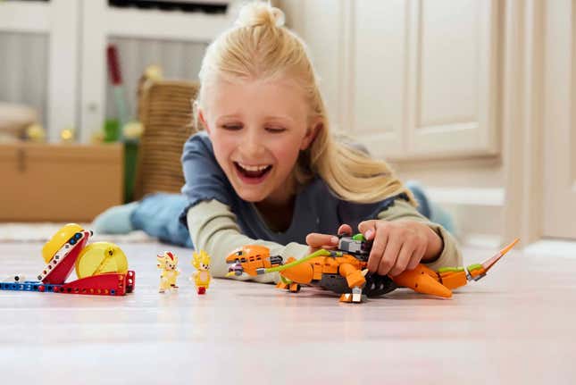 A kid plays with the Biolizard Lego.