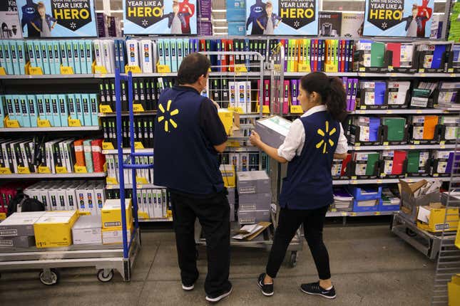 Employees restock shelves of school supplies at a Walmart in Burbank, California on Aug. 8, 2017. 