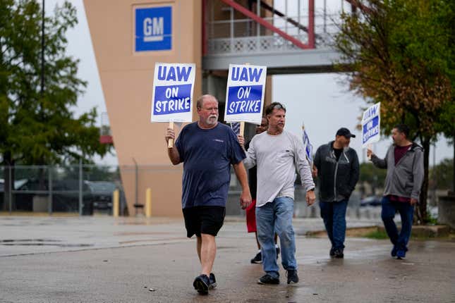 Ethan Pierce, left, a material handler of 23 years at General Motors, leads a line of picketers outside the company&#39;s assembly plant, Tuesday, Oct. 24, 2023, in Arlington, Texas. The United Auto Workers union is turning up the heat on General Motors as 5,000 workers walked off their jobs at the highly profitable SUV factory. (AP Photo/Julio Cortez)