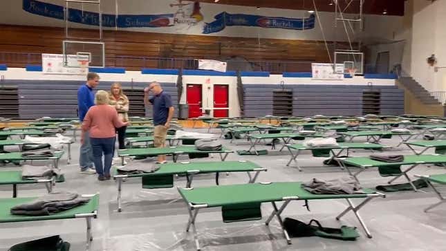 This image taken from video and provided by WTVQ shows people helping arrange cots at Rockcastle Middle School, being used as an evacuation center, in Mt Vernon, Ky., Wednesday, Nov. 22, 2023. People were evacuated from a nearby town after a CSX train derailed Wednesday near Livingston, a remote town with about 200 people in Rockcastle County. CSX says two of the 16 cars that derailed carried molten sulfur, which caught fire after the cars were breached. (WTVQ via AP)