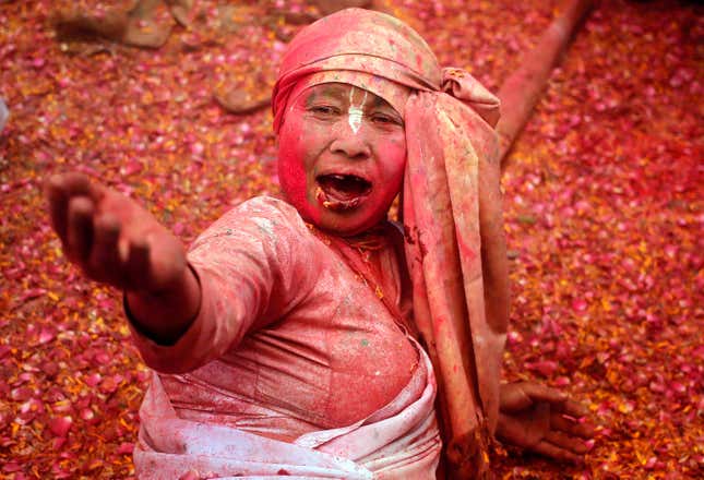 A widow sings religious songs as she takes part in the Holi celebrations.