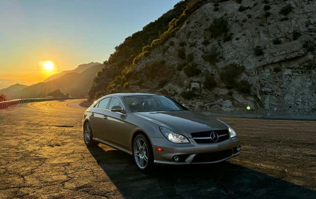 Front 3/4 view of a gold Mercedes-Benz CLS500 at sunset