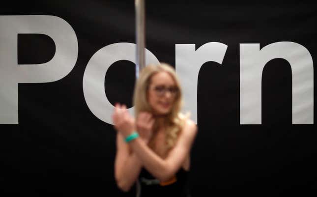 FILE - Porn actress Ginger Banks stands in the Pornhub booth during the AVN Adult Entertainment Expo, Wednesday, Jan. 24, 2018, in Las Vegas. The owner of Pornhub, one of the world’s largest adult content websites, has admitted to profiting from sex trafficking and agreed to make payments to women whose videos were posted without their consent, federal prosecutors in New York announced Thursday, Dec. 21, 2023. (AP Photo/John Locher, File)