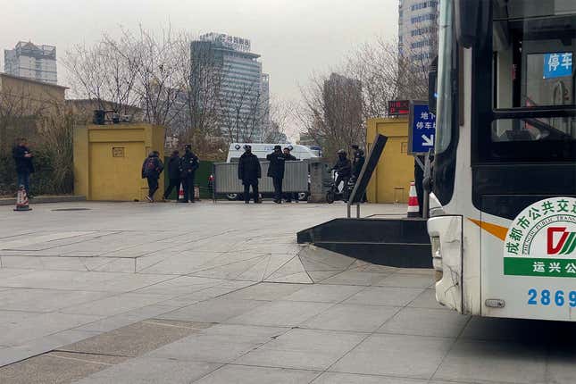 Plainclothes policemen and security personnel stand watch at an entrance gate to the Sichuan Trust office building in Chengdu in southwestern China&#39;s Sichuan Province on Feb. 27, 2024. Some investors in a troubled trust fund in China are facing financial ruin under a government plan to return a fraction of their money, casualties of a slump in the property industry and a broader economic slowdown. (AP Photo/Andy Wong)