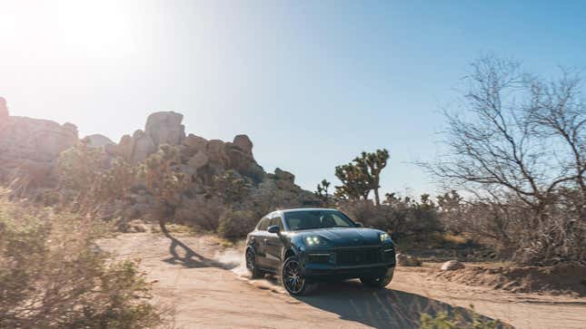 A dark blue Porsche Cayenne driving in the desert near Palm Springs