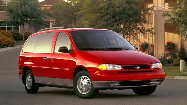 A photo of a red Ford minivan parked on a street. 