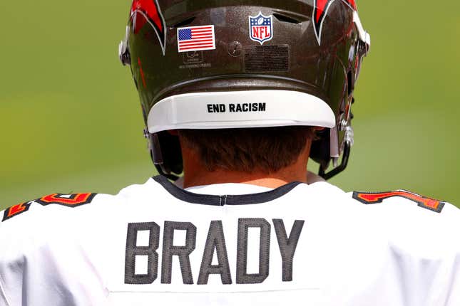 The message “End Racism” is seen on the helmet of Tom Brady #12 of the Tampa Bay Buccaneers as he warms up before the game against the Carolina Panthers at Raymond James Stadium on September 20, 2020 in Tampa, Florida. 