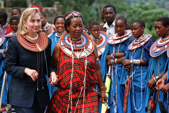 US first lady Hillary Clinton arrives in the Masai village of Olturoto with local volunteer Mama Joan Koisianga (R), after receiving a traditional Masai necklace as a gift. Mrs. Clinton is on a 6-nation goodwill tour through Africa with her daughter-Chelsea.