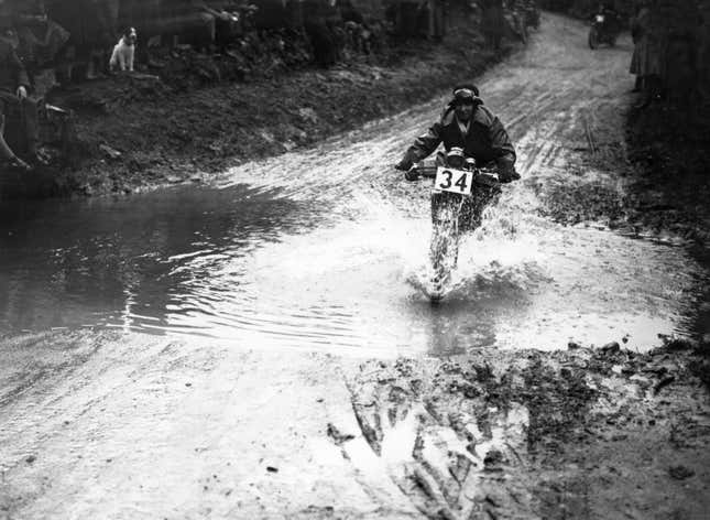 March 1923: Contestant M Lewis riding through the water splash during ACU trials at Birmingham
