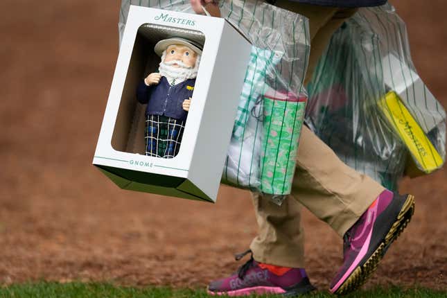 A patron carries a Masters gnome, a one-foot high ceramic figurine, during a practice round in preparation for the Masters golf tournament at Augusta National Golf Club Tuesday, April 9, 2024, in Augusta, Ga. (AP Photo/George Walker IV)