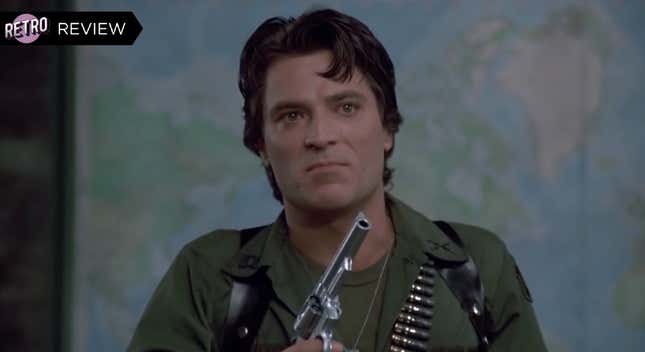 A man standing in front of a world map dressed in military fatigues and holding a gun looks angry in a scene from Day of the Dead.