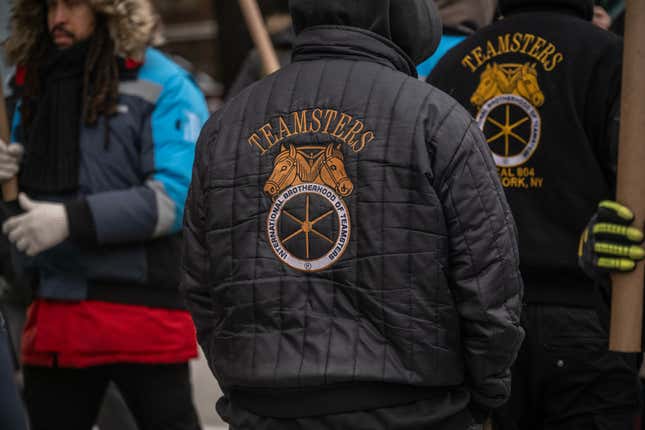 Une veste des Teamsters est portée par des travailleurs d’Amazon et des membres du syndicat lors d’un piquet de grève devant un centre de distribution dans le Queens, à New York, aux États-Unis, le vendredi 20 décembre 2024. 