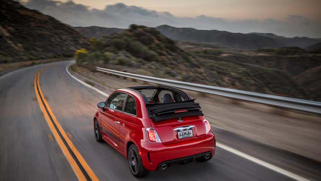 Une Fiat 500C Abarth rouge circulant sur une route de campagne