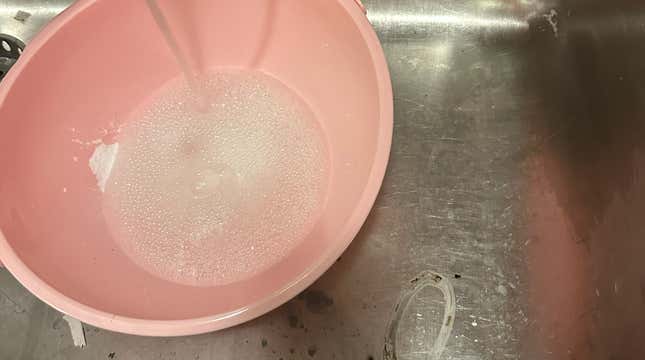 Filling a bowl with soap and water. 