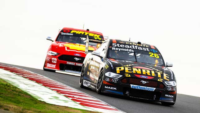 A photo of two sports cars racing at The Bend track in Australia. 