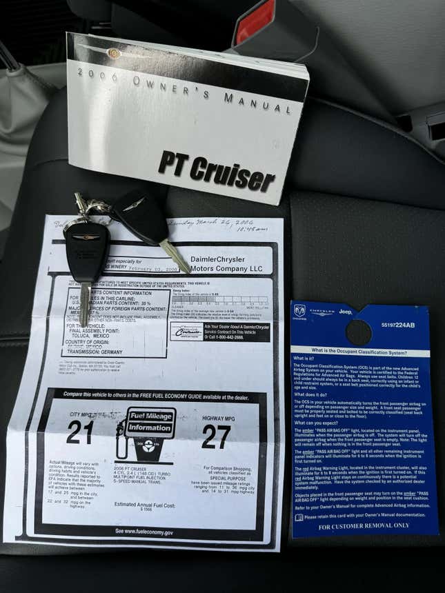 A photo of the window sticker, owner's manual and original key