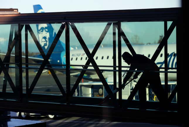 FILE - A worker cleans a jet bridge at Paine Field in Everett, Wash., before passengers board an Alaska Airlines flight, March 4, 2019. Seattle-based Alaska Airlines owns Horizon Air. Three passengers sued Alaska Airlines on Thursday, Nov. 2, 2023, saying they suffered emotional distress from an incident last month in which an off-duty pilot, was accused of trying to shut down the engines of a flight from Washington state to San Francisco. (AP Photo/Ted S. Warren, File)