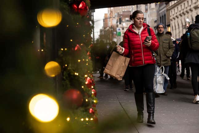 A woman carrying a shopping bag passes Macy&#39;s department store in Herald Square, Monday, Dec. 11, 2023, in New York. On Thursday, the Commerce Department releases U.S. retail sales data for November. (AP Photo/Yuki Iwamura)