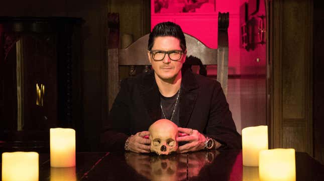 Ghost Adventures host Zak Bagans sits at a table with a skull and candles.